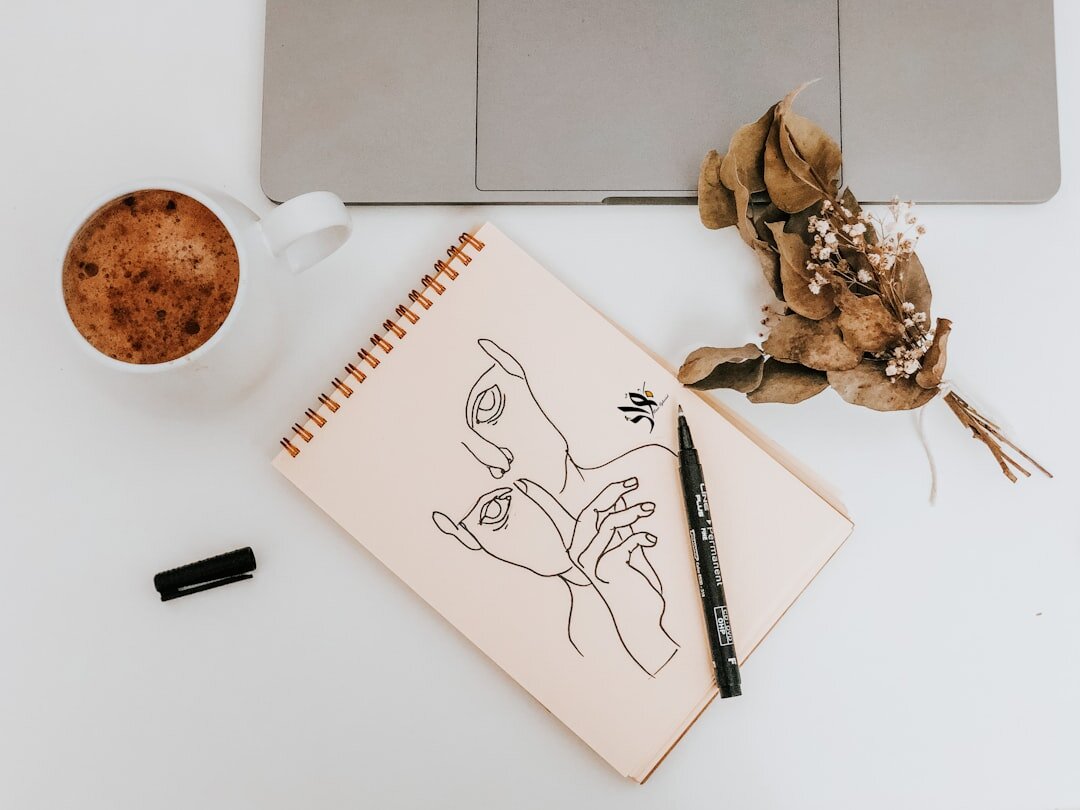 Open notebook with business plan sketches next to a laptop and coffee
