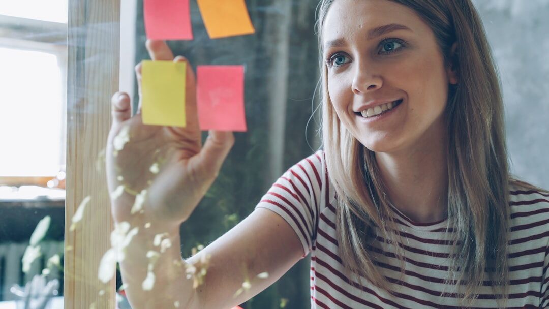 Small group of people brainstorming with sticky notes on a glass wall